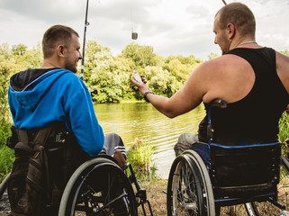 Handicapped men fishing at a lake. Wheelchair. Camping.