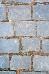 Old aged granite paving stones. Texture of old granite paving stones. The texture of the pavement granite pattern wallpaper for design. Rough texture vertical.