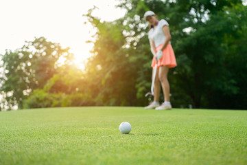 Woman driving practice golf or trainer at golf course on the fairway at sunset