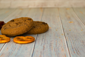 Baked oatmeal cookies and bagel lie on a light wooden table. There is a place for text. Concept breakfast, holiday, cooking. Blurred background.