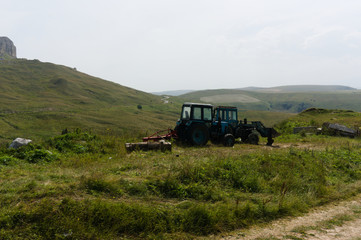 farm tractor on lawn meadows in the caucasus landscape near mount elbrus at the gumbashi pass