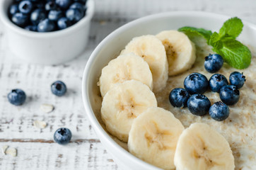 Oatmeal with bananas and blueberries. Healthy breakfast.