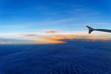 Naklejka na ściany i meble Airplane wing against sky at sunset