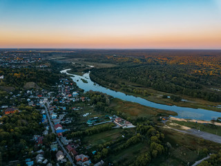 Summer rural landscape, aerial view. Village, forest and river from drone flight