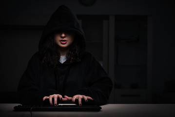 Female hacker hacking security firewall late in office