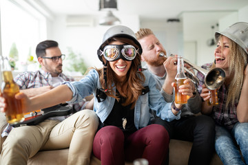 Cheerful friends having party together and playing instruments