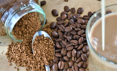 coffee beans, a can of instant coffee and a coffee mug with milk