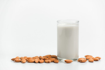 Milk with almonds nut on white background.