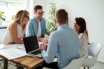 Group of business people working and communicating while sitting at the office desk together