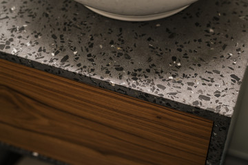 Closeup detail shot of gray terrazzo bathroom cabinet with black marble