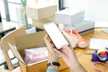 Online seller use mobile phone to take picture of products in box send to customer.