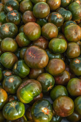 Close up view at black tomatoes Kumata. Food background with selective focus. Huge fresh products on marketplace