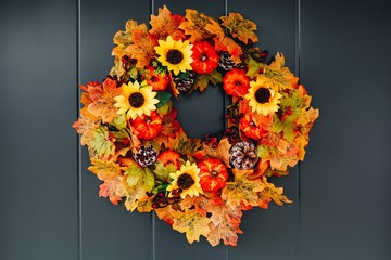 Autumn wreath with sunflowers, pumpkins and maple leaves on front door - Powered by Adobe