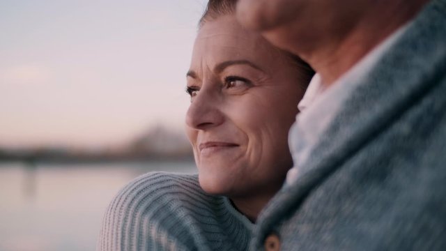 Man and woman hugging each other by the water