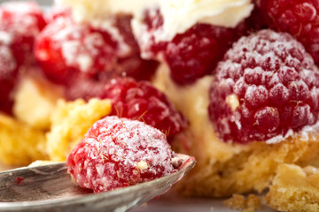 Eating from a baked cake with raspberries