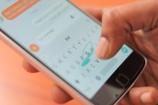 Close up of a man hand typing by using swype keyboard on mobile smart phone.