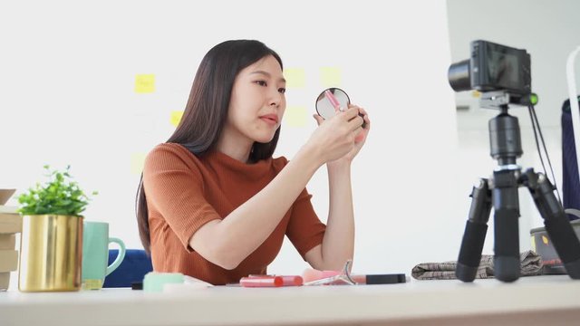 Young Asian woman recording a video for a woman beauty blogger. Makeup lipstick Tutorial