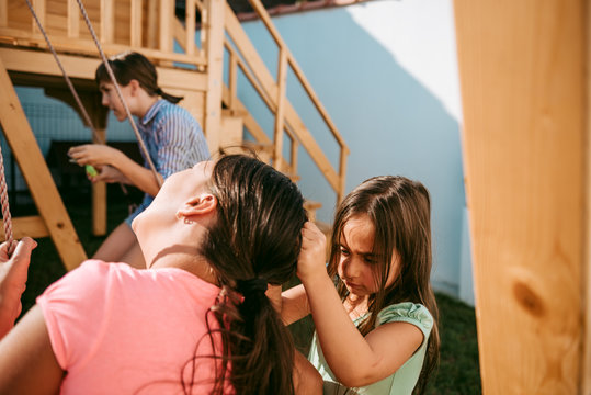 Two girls fighting at the playground for the swing