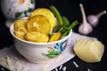 baked potatoes with cheese and asparagus on canvas on a dark wooden background