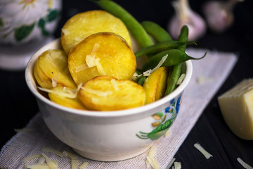baked potatoes with cheese and asparagus on canvas on a dark wooden background