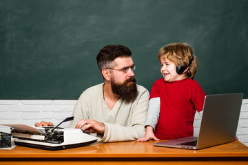 Daddy and his little son. Young adult concept. Chalkboard background. Back to school and Education concept. Elementary school teacher and student in classroom. Little students