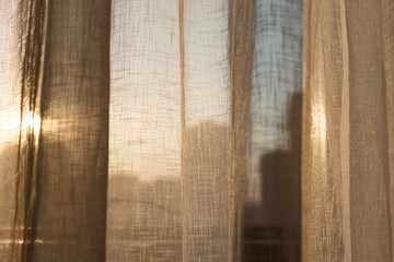 cortina na janela deixando o sol passar