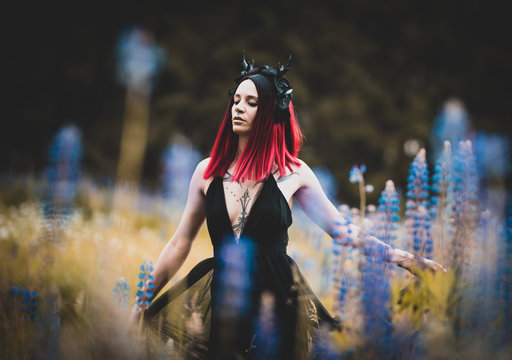 T&auml;towiertes Model im Maleficent Look zwischen blauen Blumen