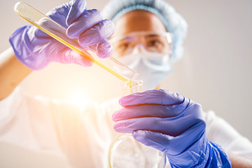 Scientist pouring organic oil. Beauty and cosmetics sciences. Laboratory equipment
