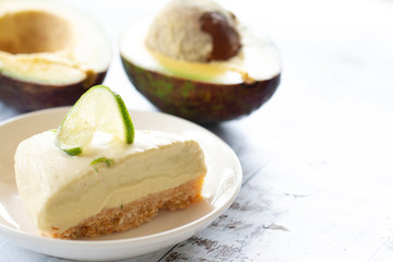 Home made avocado lime cheesecake on a white wood background
