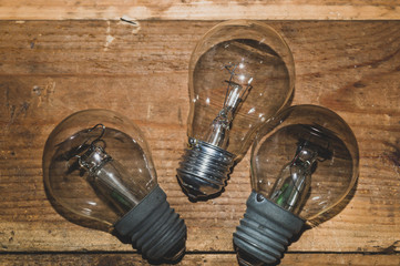 Light bulb on a wooden background. old glass lamp lies on the table