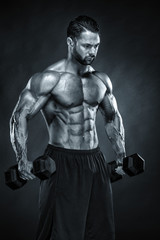 Fototapeta na wymiar Handsome Bodybuilder Exercise With Dumbbells