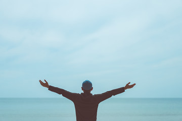 Copy space of man raise hand up on blue sky at beach and island background. © tonktiti