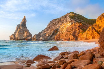 Obraz premium Small Beach Surrounded by Cliffs at Sunset
