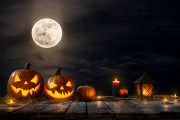 Halloween pumpkins on dark spooky forest with blue fog in background.