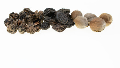 triphala ayurvedic medicinal plant comprise of  organic chebulic myrobalan fruit, organic amla fruit, and organic belleric myrobalan fruit on white background with copy space