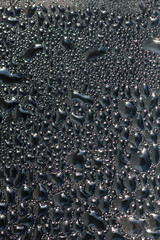 Drops of black liquid on a glass surface