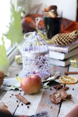 Fototapeta na wymiar Cup with mulled wine, autumn leaves, seasonal fruits and vegetables, decor, spices on a window background, home comfort concept