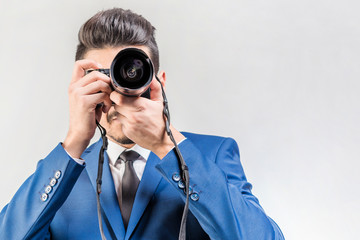 A man in a blue suit takes pictures. Close-up.