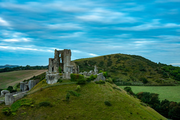 Fototapeta na wymiar Ruins of Corfe Castle during blue hour with Purbeck hills behind in a long exposure photography, Isle of Purbeck, Dorset, England