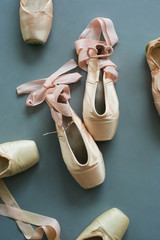 Pointe shoes with pink silk ribbon. Old used ballet slippers on the floor. © DenisProduction.com