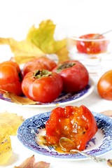 ripe juicy persimmons on a light background. You can eat with spoons like jelly. autumn still life flat. autumn leaves.