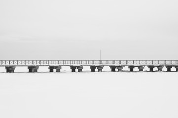 Bridge on the frozen lake. footbridge dividing the horizon. conceptual minimalistic image. black and white background