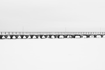 Bridge on the frozen lake. footbridge dividing the horizon. conceptual minimalistic image. black and white background