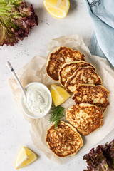 Vegetable (cauliflower) pancakes (fritters) with natural yogurt dressing and dill.