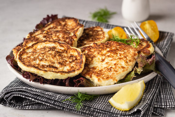 Vegetable (cauliflower) pancakes (fritters) with natural yogurt dressing and dill.