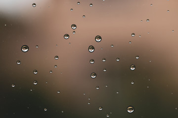 Raindrops on window glass close up. water drops abstract macro background