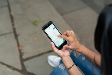 woman sitting sending text message on phone