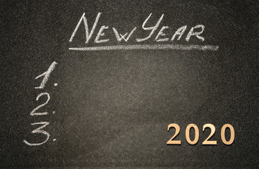 Fototapeta na wymiar New year resolution on a blackboard. Chalk inscription New Year and 2020 on blackboard