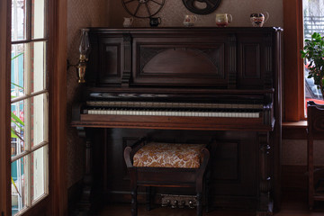 Fototapeta na wymiar old vintage retro dark brown wooden piano in the interior