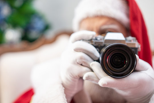 Santa Claus holding vintage camera. Portrait Isolated on yellow background.